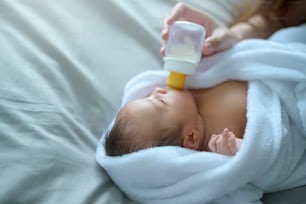 Portrait of Cute new born baby drinking milk bottle.