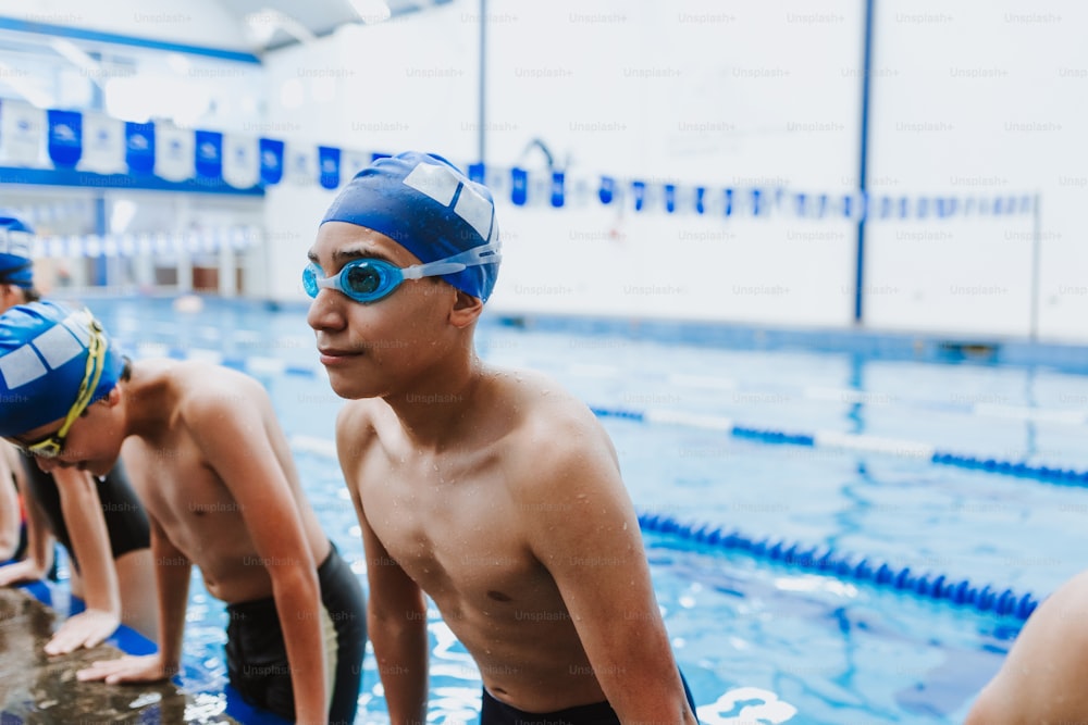 latin young man swimmer wearing cap and goggles in a swimming training at the Pool in Mexico Latin America