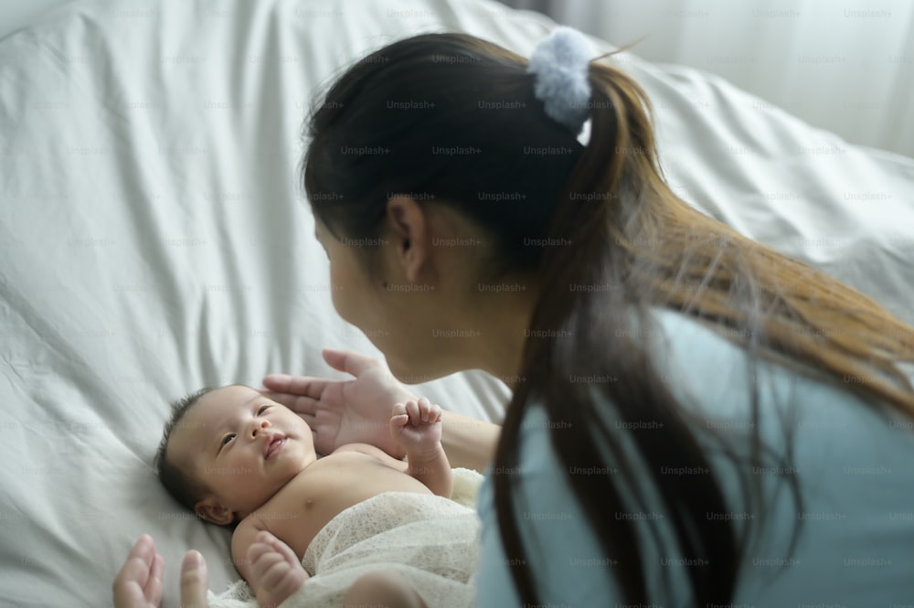 Uma jovem mãe com um bebê recém-nascido bonito.