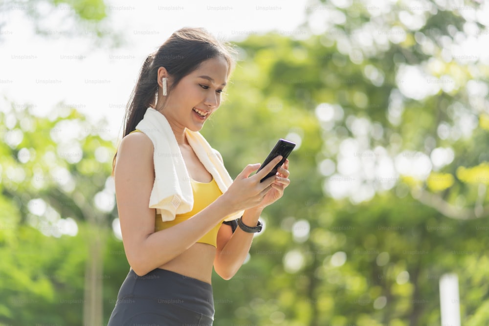 esporte ativo asiático pano esportivo feminino configuração smartphone jogando preparar para sua rotina de corrida treino manhã estilo de vida saudável, sorridente mulher esportiva definindo rota de corrida em seu mapa de aplicação