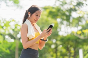 Sport aktiv asiatische weibliche Sportkleidung Einrichten Smartphone spielen Vorbereitung auf ihre Laufroutine Workout Morgen gesunder Lebensstil, lächelnde Sportlerin Setting Laufroute in ihrer Anwendungskarte