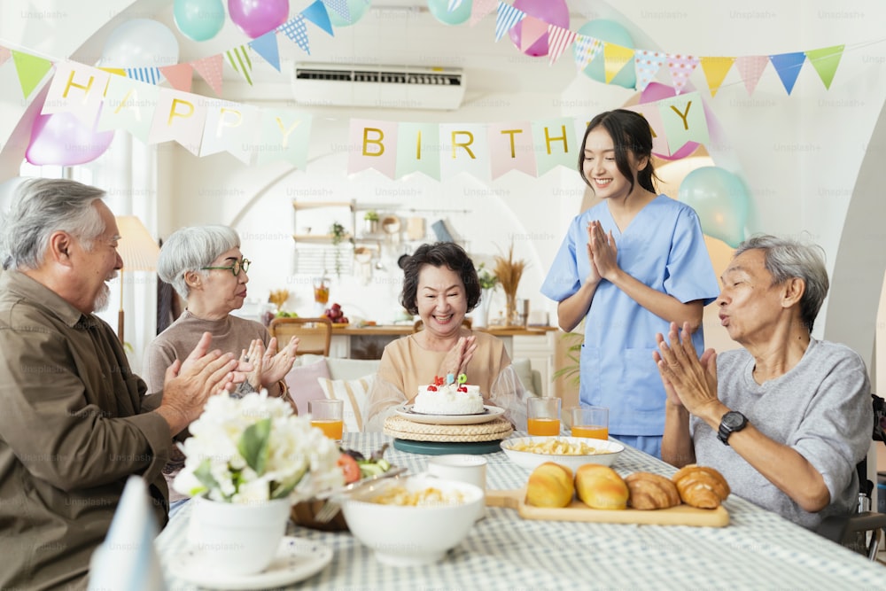 Geburtstagsfeier in der Seniorentagesstätte, Gruppe asiatischer weiblicher älterer männlicher weiblicher Lachen Lächeln Positive Konversation Begrüßung in Geburtstagsfreund Party im Pflegeheim Seniorentagesstätte Seniorin Frau Geburtstag