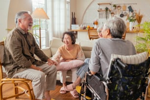 古い先輩アジアの友人 退職した人の幸せ 肯定的な笑い 笑顔 老人ホームのリビングルームで一緒に会話 大人のデイケアセンターでのグループ活動に参加している高齢者