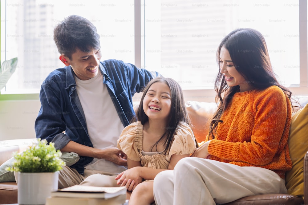 fun and joyful exiting moment asian family parent and daughter sit together watching online streaming concert together on sofa couch in living room at home,happiness family dance moving hand cheerful