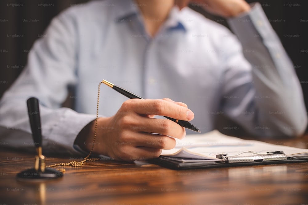 비즈니스 변호사 문서 승인 개념, 현대 사무실에서 계약 서류 또는 금융 계약을 수락하기 위해 펜을 사용하여 서명하는 전문 사업가