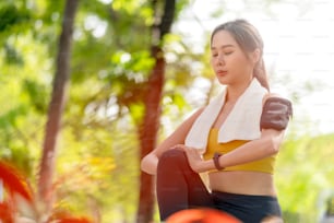 asiatico allegro giovane adulto Attraente e forte stretching mattutino prima di runin the park Concetto di sport. Stile di vita sano Giovane corridore della donna di fitness che si allunga prima di correre sul parco