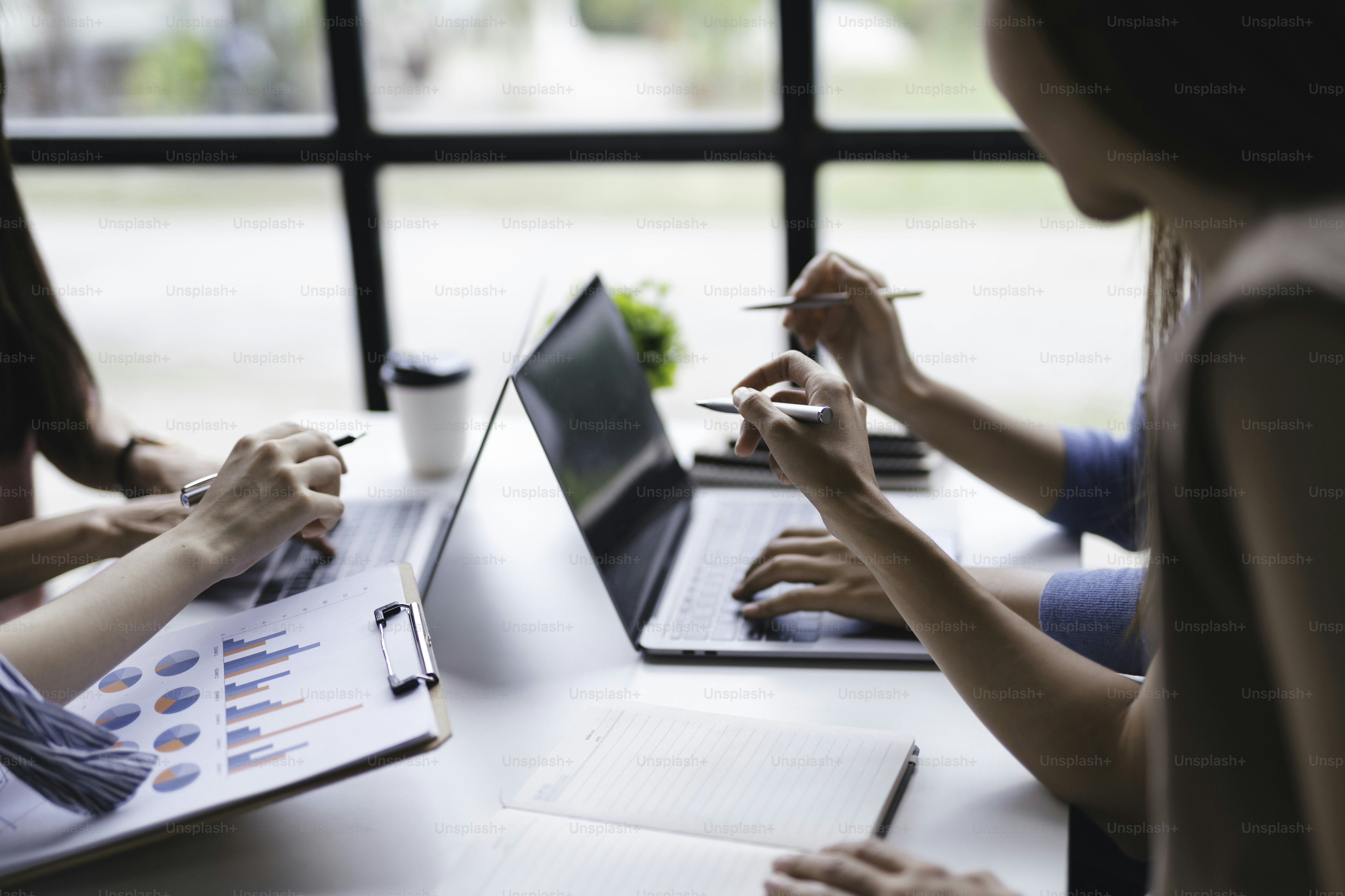 Team aziendale che lavora insieme pianificando l'investimento durante la riunione. Vista ravvicinata dei consulenti degli uomini d'affari che indicano il grafico e analizzano il rapporto finanziario.
