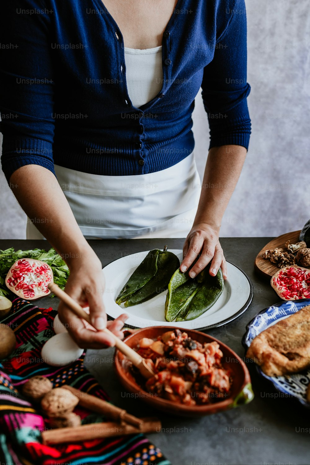 メキシコの女性がポブラノ唐辛子と食材を使ったノガダのレシピを調理するメキシコの女性、プエブラメキシコの伝統料理