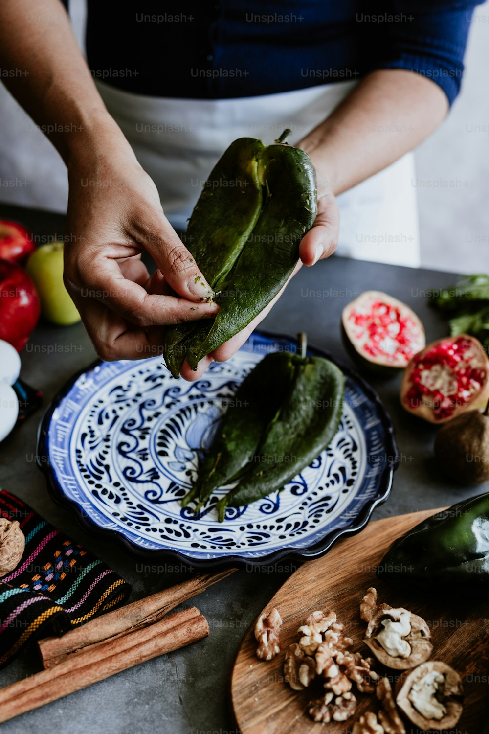メキシコの女性がポブラノ唐辛子と食材を使ったノガダのレシピを調理するメキシコの女性、プエブラメキシコの伝統料理