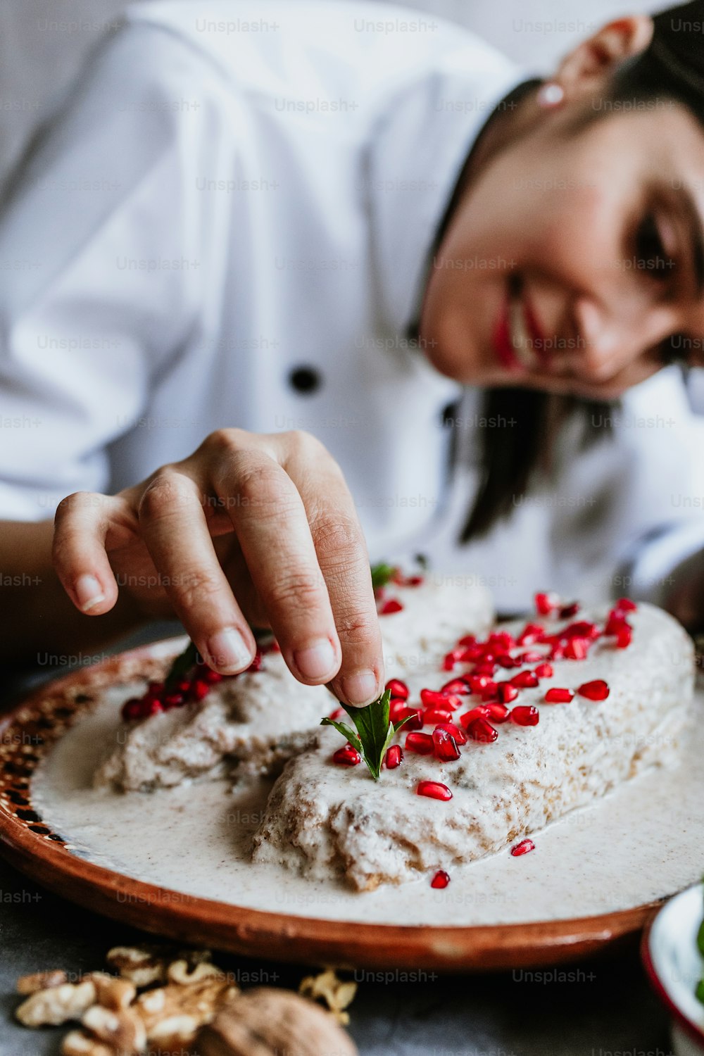 メキシコの女性シェフがポブラノ唐辛子と食材を使ったノガダのレシピを調理するメキシコの女性シェフ、プエブラメキシコの伝統的な料理