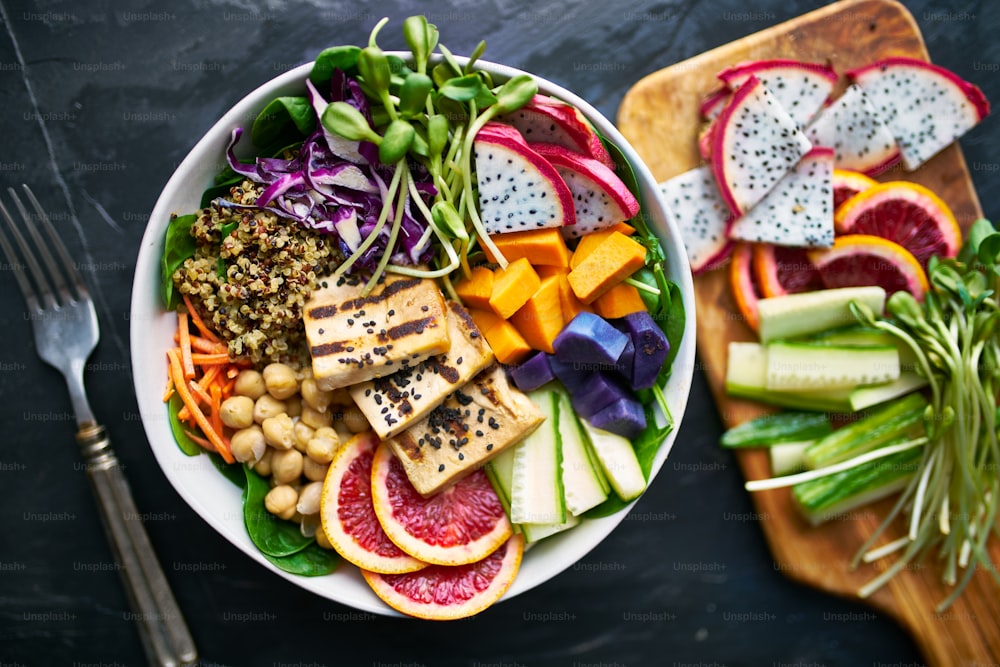 Tofu a la parrilla y fruta del dragón Buda Bowl vista superior, también tiene garbanzos y rodajas de naranja sanguina