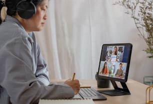 asian woman video conference business meeting with colleague online with tablet at home