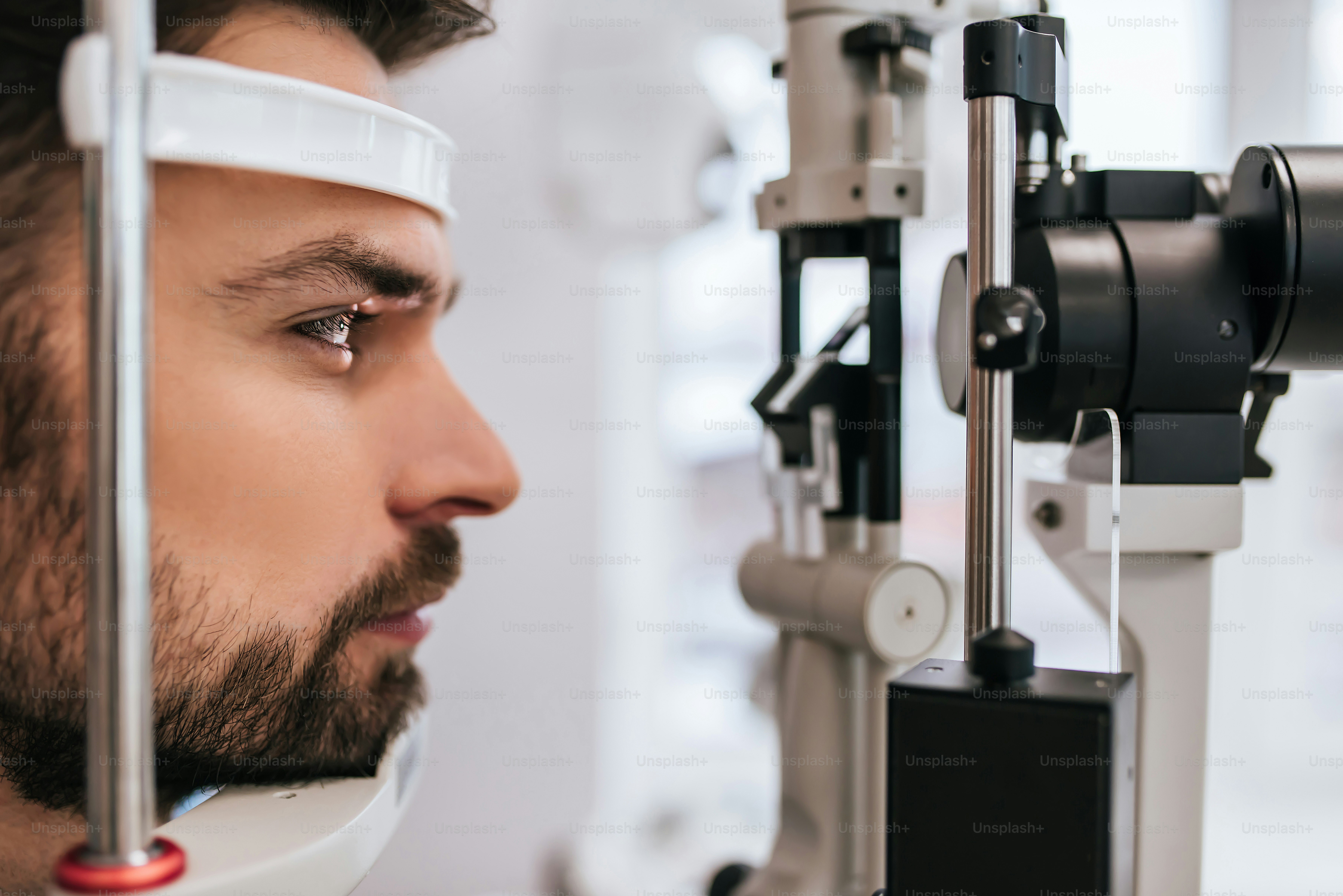Un bel giovane sta controllando la visione degli occhi nella moderna clinica oftalmologica. Paziente in clinica oftalmologica