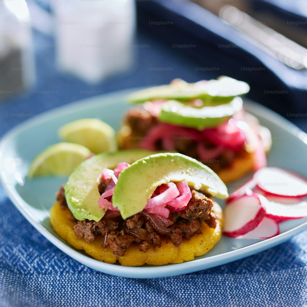 beef arepas with avocado and pickled onion on plate