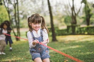 little girl children playing tug of war at the park