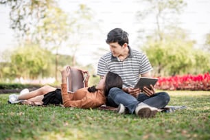 Asian couples reading a book . Couple of students with a books. Education in nature park