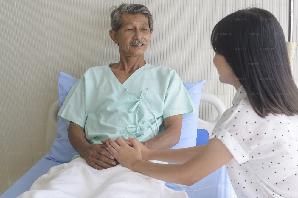Eine kleine Tochter besucht kranken alten Vater im Krankenhaus, Gesundheits- und Medizinkonzept