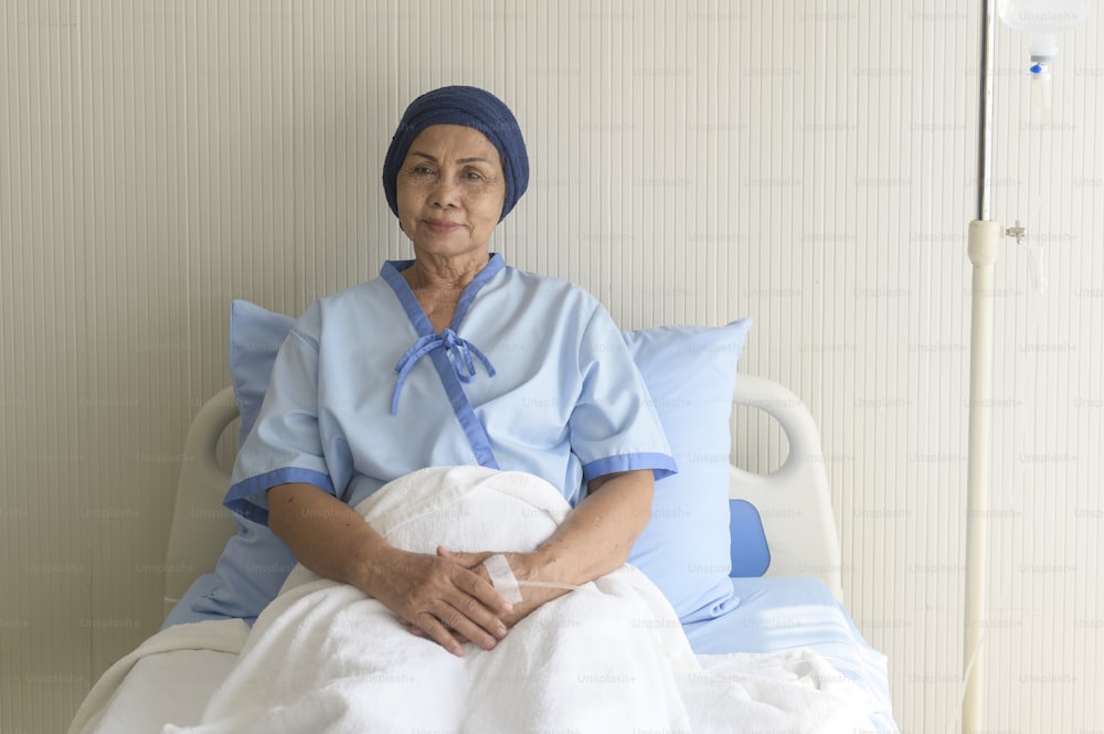 Retrato da mulher paciente com câncer sênior que usa lenço de cabeça no hospital, saúde e conceito médico