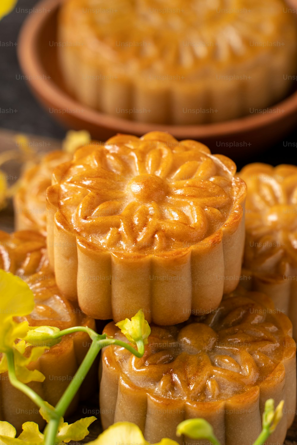 Mooncake, bolo da Lua para o Festival do Meio do Outono, conceito de comida festiva tradicional na mesa de ardósia preta com chá e flor amarela, close-up, espaço de cópia.
