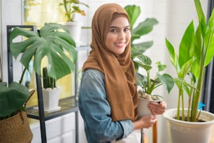 Uma jovem mulher muçulmana feliz que desfruta e relaxa a atividade de lazer no jardim em casa