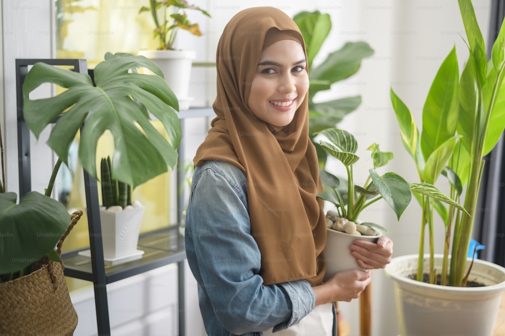 Une jeune femme musulmane heureuse appréciant et relaxant l’activité de loisirs dans le jardin à la maison