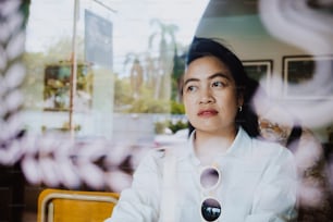 窓の反射の近くのコーヒーショップに座っているアジアの女性は、感情、余暇のライフスタイルをリラックスさせます
