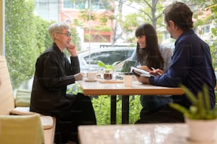 Group of business people brainstorming in coffee shop
