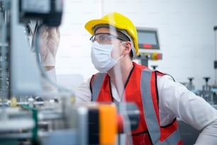 Ingeniero de control de calidad (QC) que monitorea y verifica el sistema de la máquina en la fábrica de fabricación