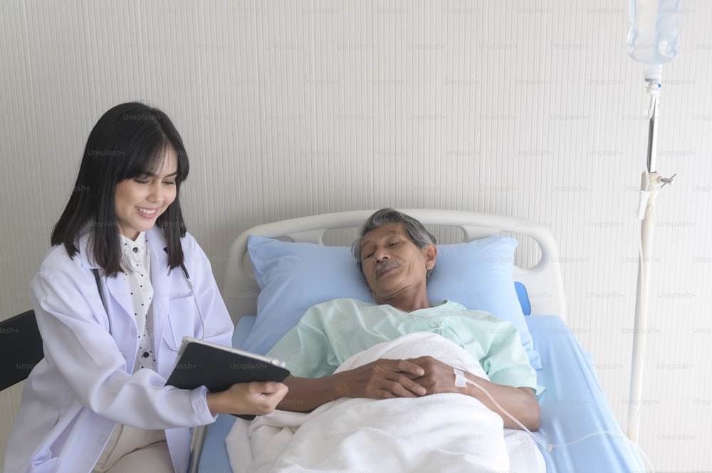 Il paziente maschio anziano asiatico sta consultando e visitando il medico in ospedale..
