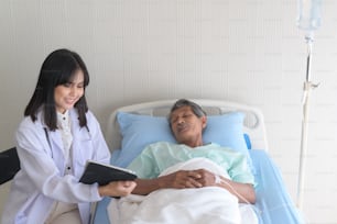 Un paciente masculino asiático de la tercera edad está consultando y visitando al médico en el hospital.
