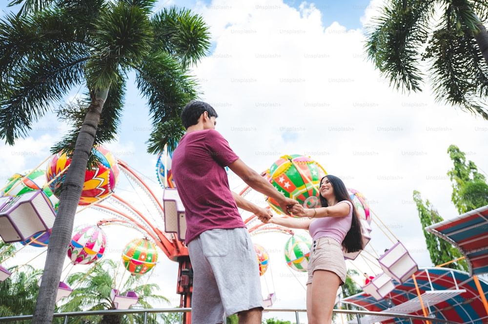 young couple having fun at an amusement theme park. Dating Relaxation Love at Theme Park, have fun and happy smile concept