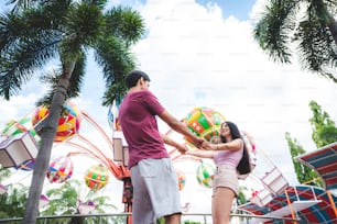 young couple having fun at an amusement theme park. Dating Relaxation Love at Theme Park, have fun and happy smile concept