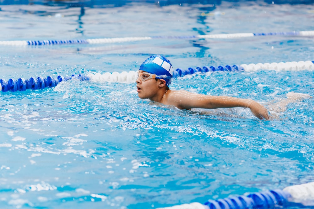 nuotatore latino del ragazzo del bambino che indossa il cappuccio e gli occhialini in un addestramento di nuoto alla piscina in Messico America Latina