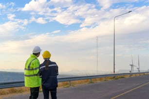 people engineer are wearing a protective helmet on head, using tablet Analytics engineering data.