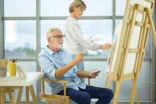 Senior caucasian couple painting and relaxing at home