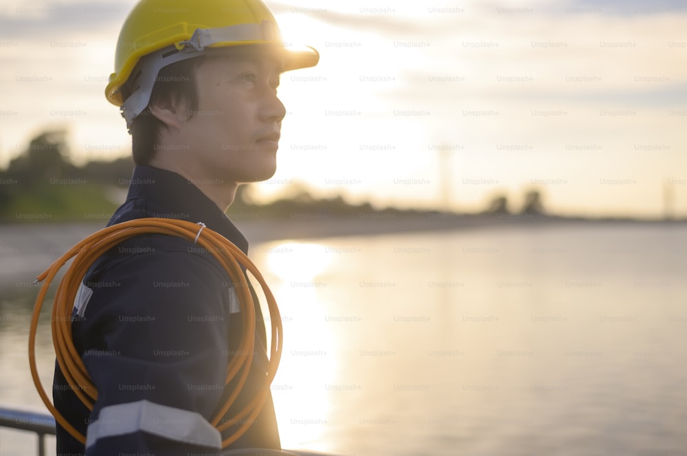 Un ingegnere maschio che indossa un casco protettivo al tramonto.
