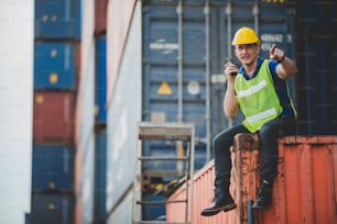 foreman worker manager working outdoor site, cargo container site, control plan working, working with safety equiments, helmet safety vest, technology walkie talkie concept.pointing finger