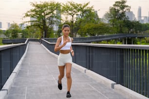 A young fitness woman in sportswear jogging in city park, Healthy and Lifestyles.