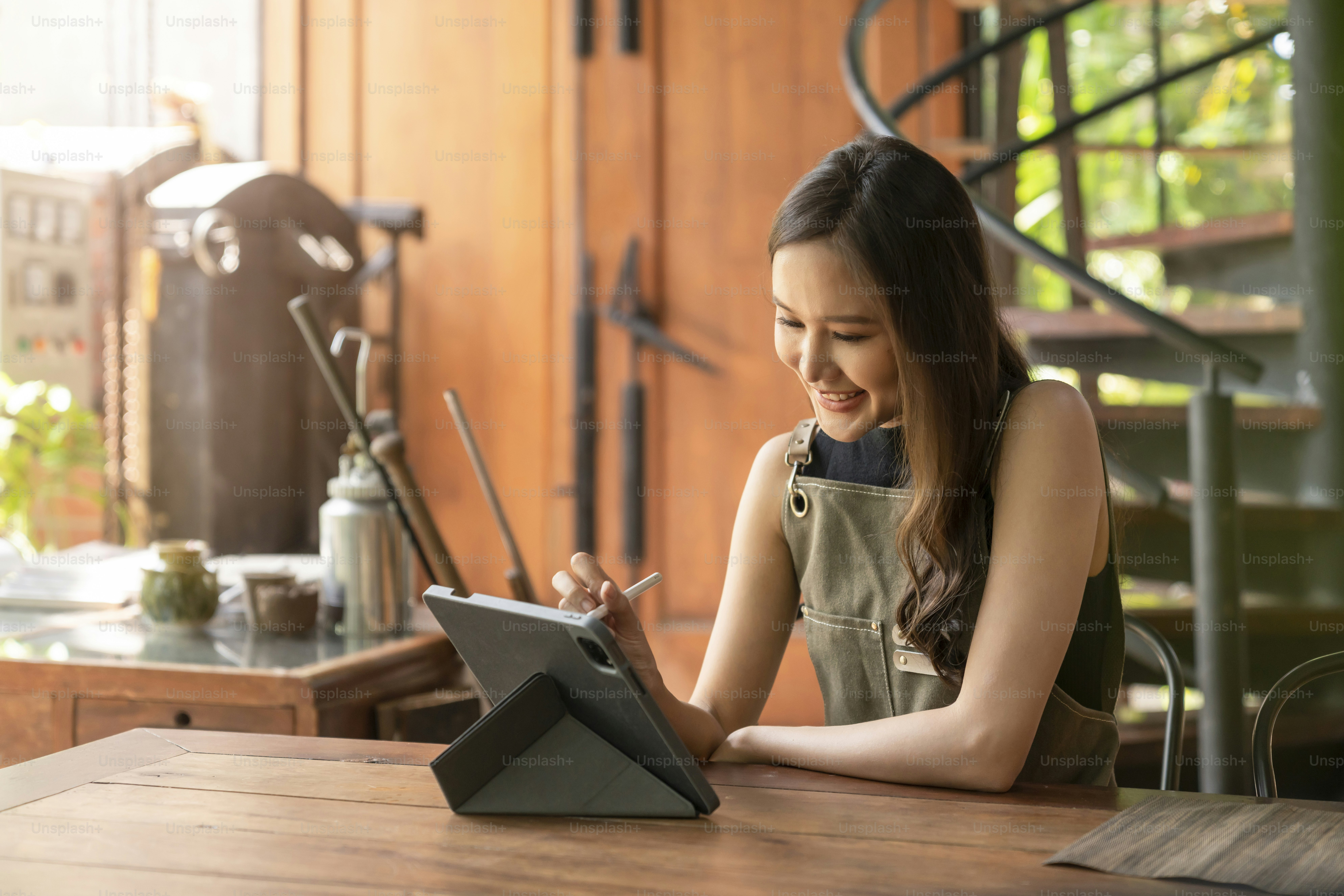 asian female adult creative designer happiness thinking work and reserach and make note of interesting ideas via tablet device,asian woman wokring casual relax at her home studio with positive emotion