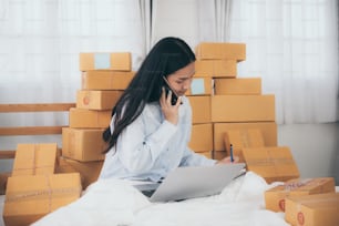 Young woman entrepreneur selling online product and use laptop in her workplace.