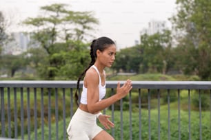 A young fitness woman in sportswear exercising in city park, Healthy and Lifestyles.