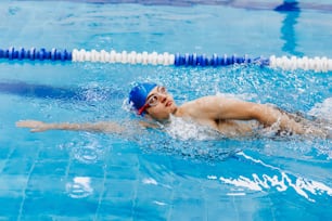 hispanic young man swimmer athlete wearing cap in a swimming training at the Pool in Mexico Latin America