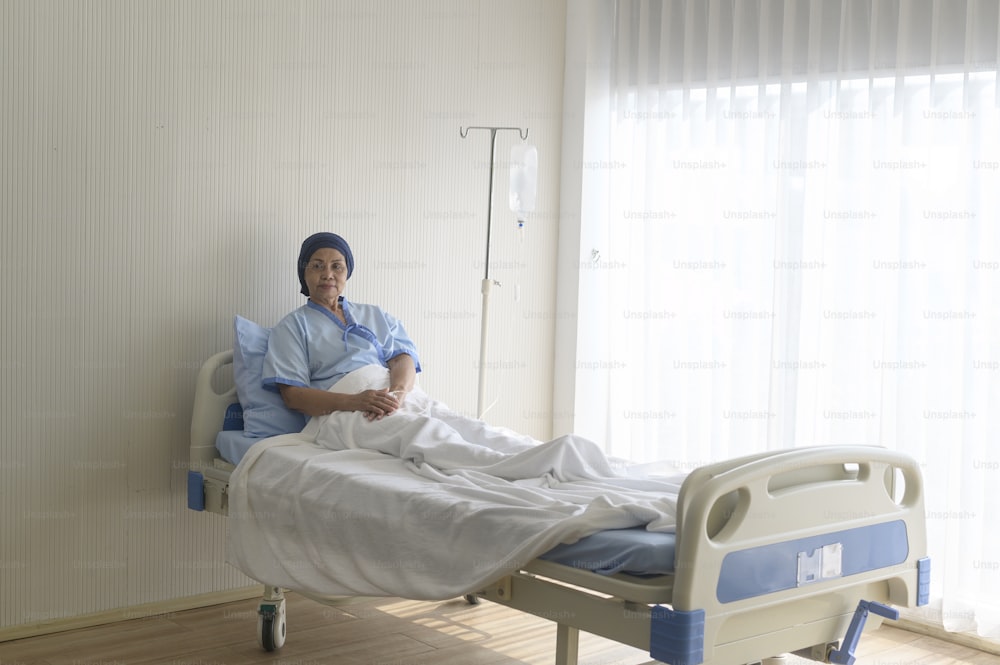 Ritratto di donna paziente anziana del cancro che indossa il foulard in ospedale, assistenza sanitaria e concetto medico