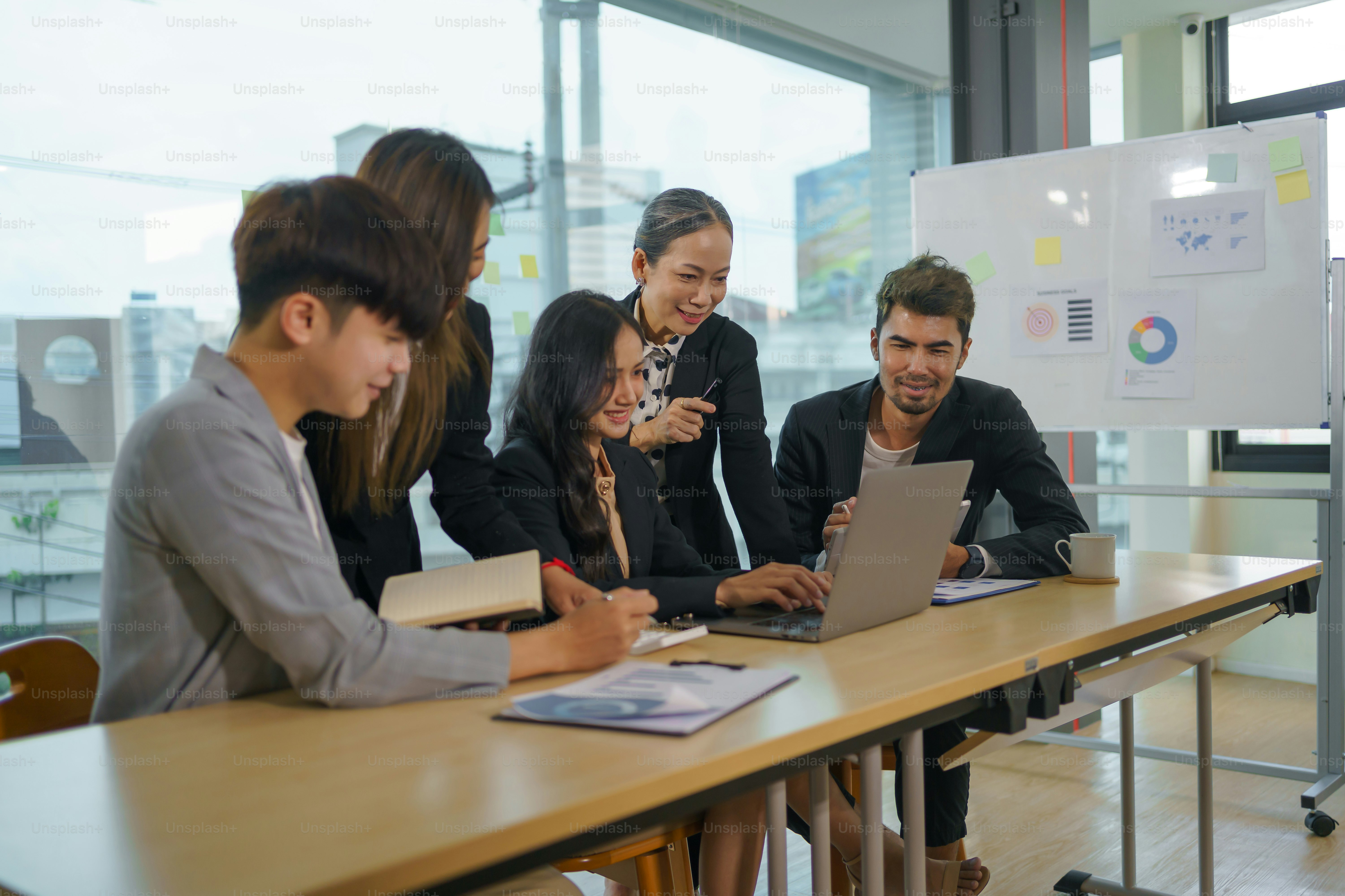 Personas colaborando en una oficina moderna con pantallas que muestran gráficos e interfaces de inteligencia artificial
