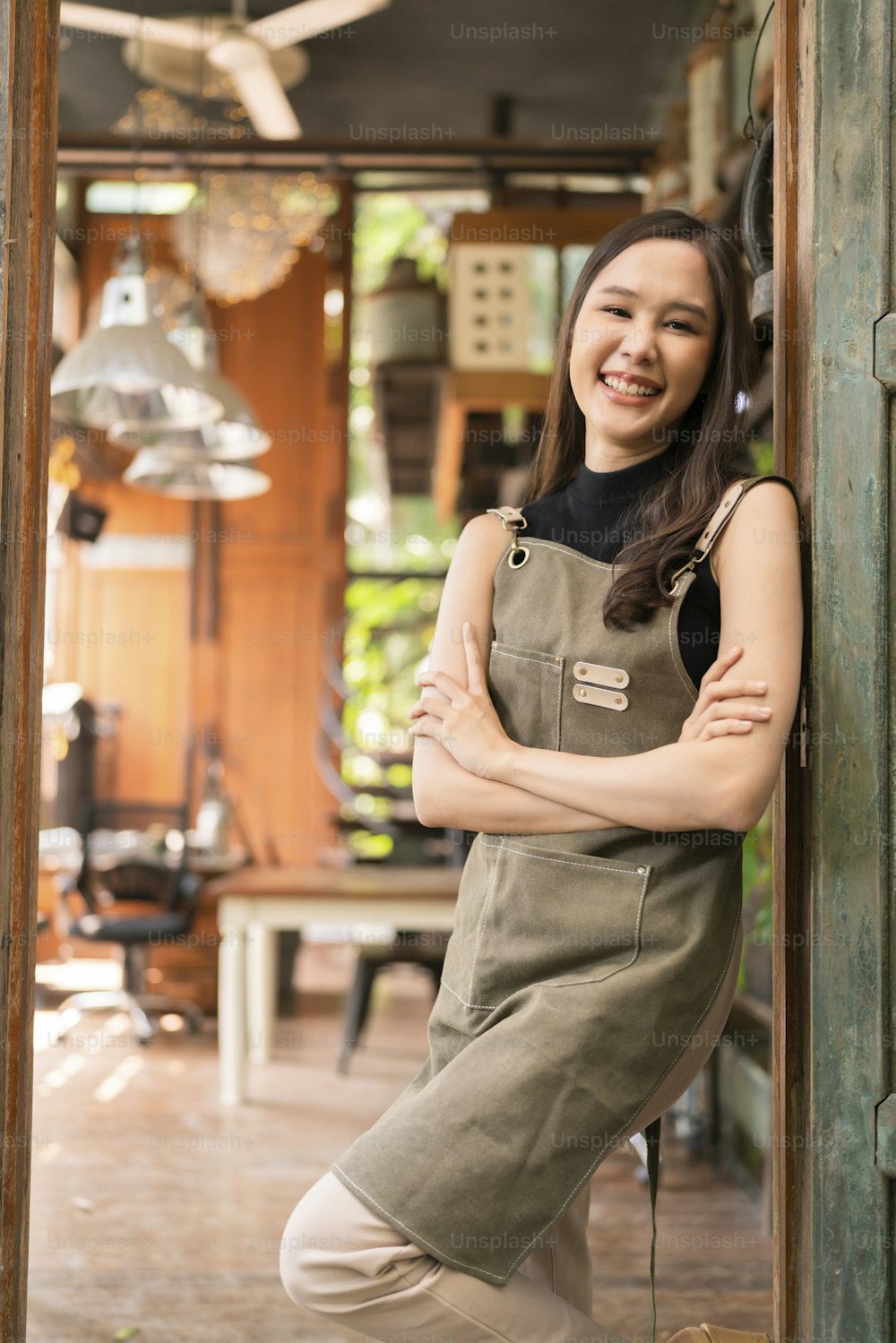 portrait of asian adult female woman wear apron standing at entrance of her workshop pottery studio incasual cloth relax smiling confident and warm welcome,asian woman with her home studio workshop
