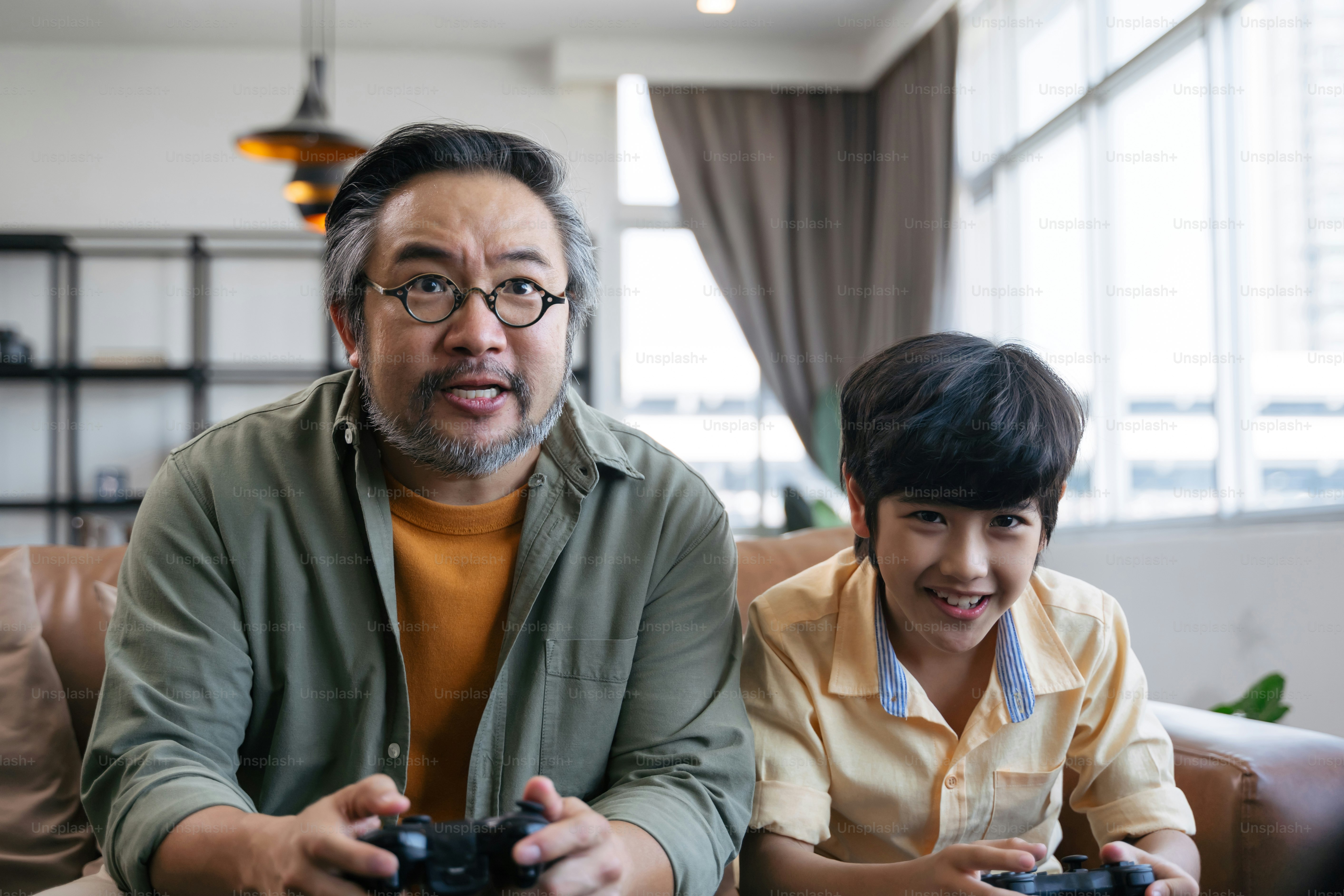 Son and dad playing video game at home photo – Video gaming Image on ...