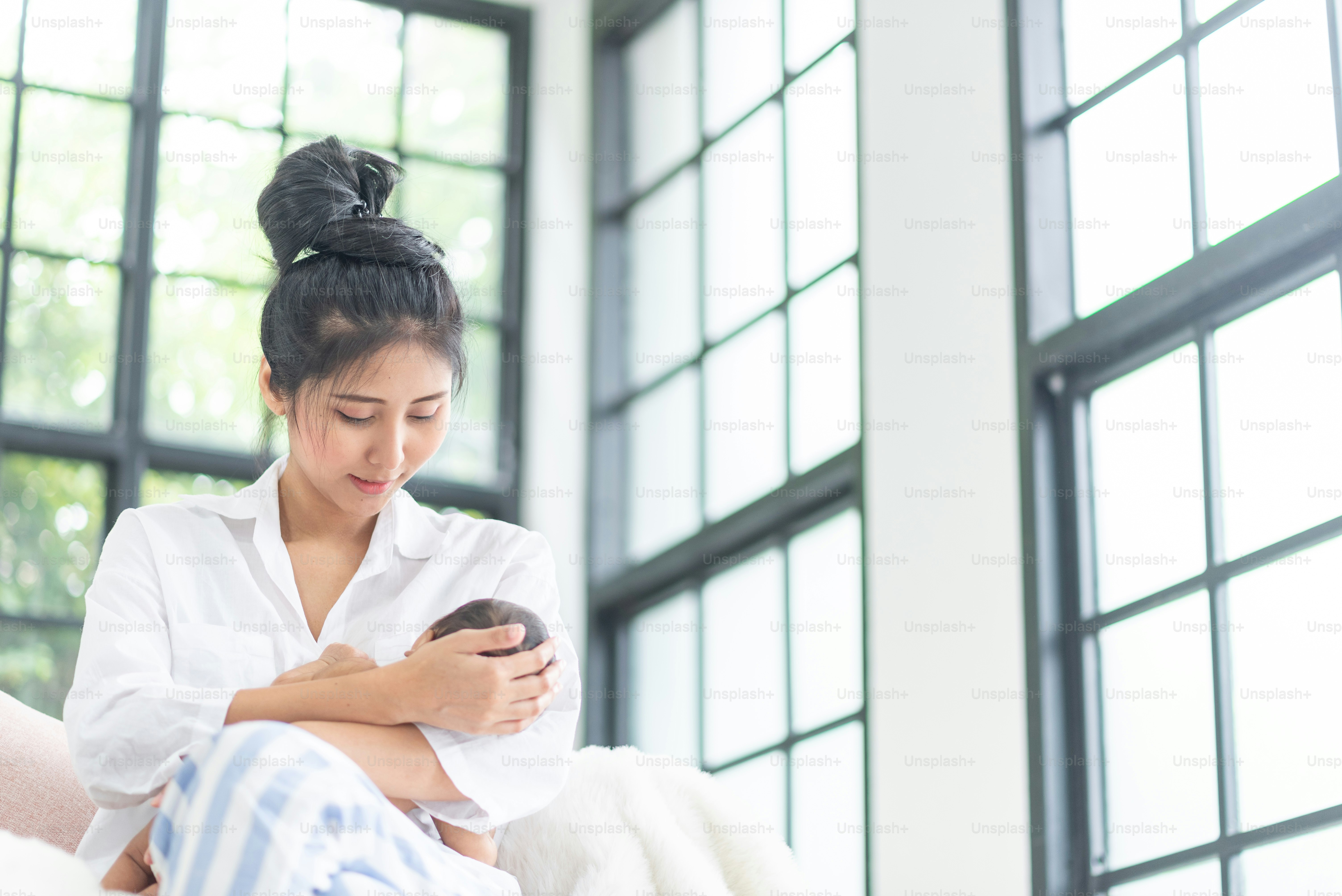 A young mother carries a baby
