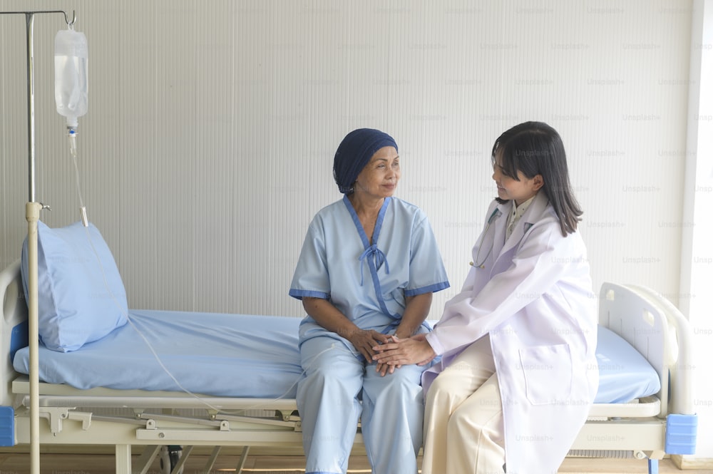 病院で高齢のがん患者の手を握る医師、ヘルスケア、医療コンセプト