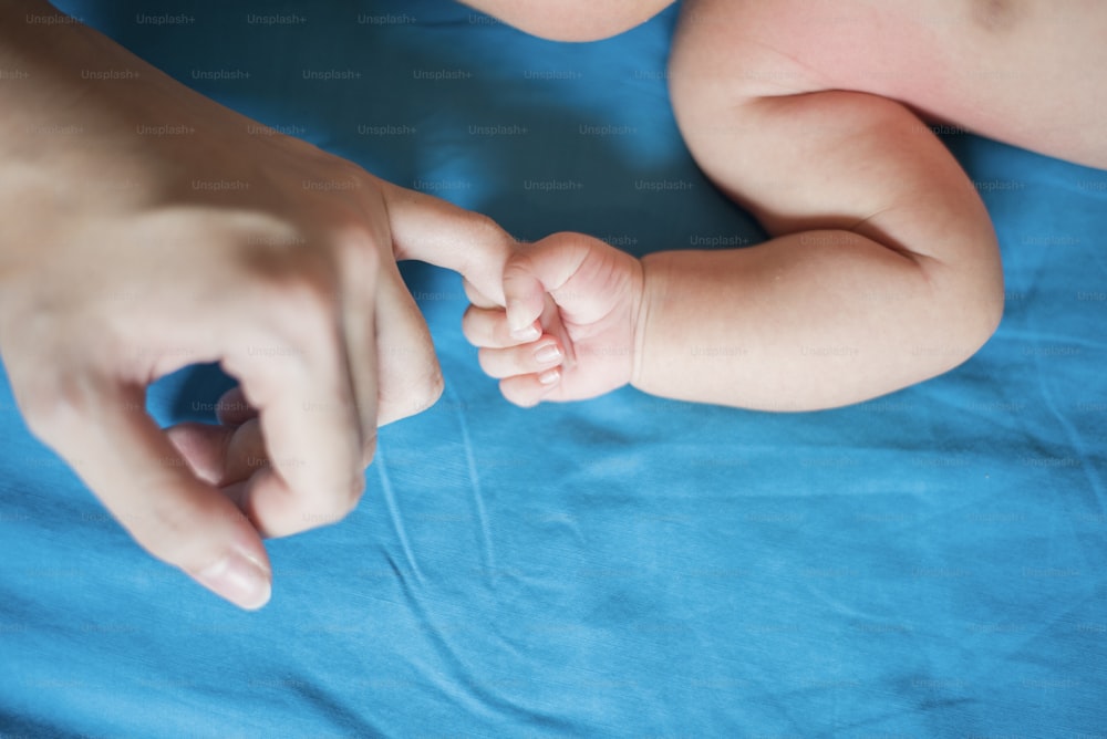 Primo piano della mano del neonato nella mano della madre durante il sonno