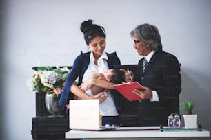 businesswoman is working by holding her baby